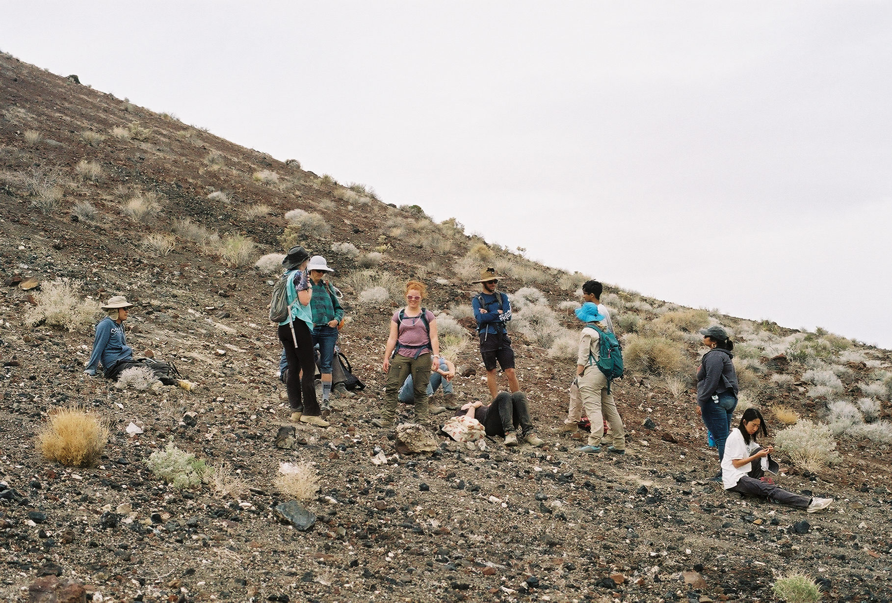 Students take a rest on the steep face of a volcanic crater. Film image by Harry Tang.
