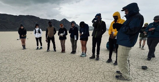 Students standing on dry cracked land