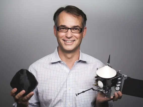 LPL Professor Dante Lauretta, OSIRIS-REx PI, with models of Bennu and spacecraft