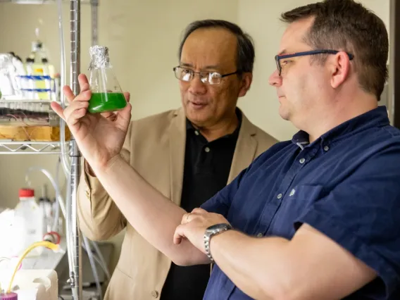 Astrobiologist Daniel Apai (right) and biosystems engineer Joel Cuello (left) work with algae in the lab.