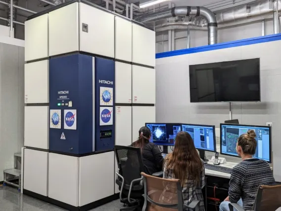 Students using the transmission electron microscope (TEM), to study a meteorite sample at the Kuiper Materials Science Facility. 