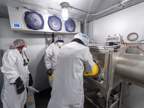 Three ARES scientists process frozen Apollo 17 samples inside a walk-in freezer maintained at minus 4 degrees Fahrenheit (minus 20 C). Beneath the laboratory gown, they don parkas, gloves, and hats to keep warm. Credits: NASA/Robert Markowitz