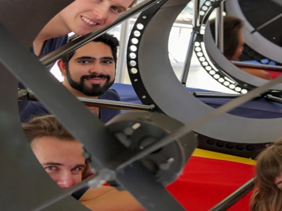 Undergraduate students Ryan Bronson, Sameep Arora, Damon Marco Colpo, Lindsie Jeffries, and Evelyn Hunten peer out from a telescope they built to track satellites.