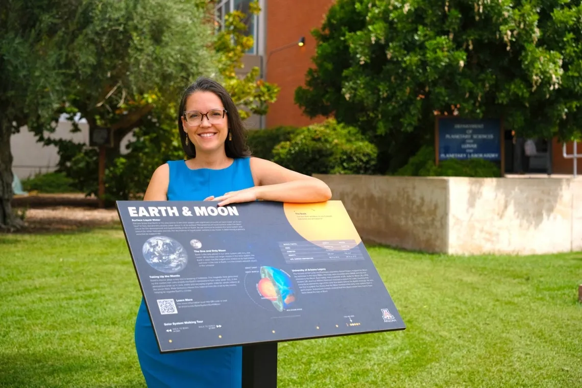 Zarah Brown, a doctoral student at the UArizona Lunar and Planetary Laboratory with sign depicting various Earth & Moon